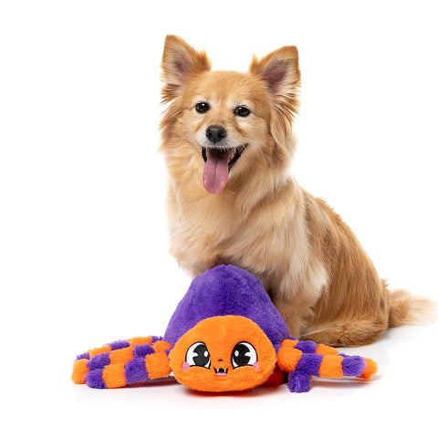 Hond speelt met een paarse pluche spin met uitgespreide poten