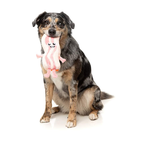 Hond speelt met FuzzYard Meat Head Kevin Bacon – duurzaam pluche hondenspeeltje in de vorm van een plak bacon met lachend geborduurd gezicht en roze pootjes