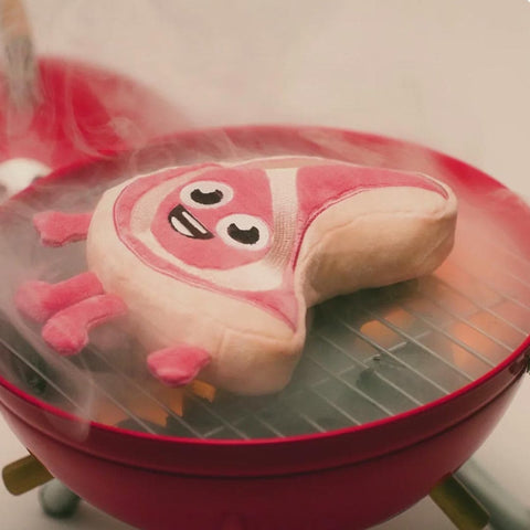 Video van FuzzYard Meat Head Piggy Smalls – pluche hondenspeeltje dat 'gebakken' wordt op de BBQ, uniek en duurzaam speelgoed voor honden