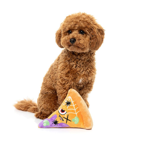 Hond speelt naast een pluche pizzapunt