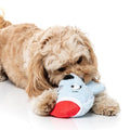 Hond speelt liggend met een lichtblauwe pluche ijsbeer als hondenspeeltje