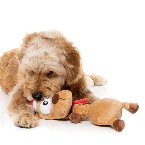 Hond ligt met een pluche rendier als hondenspeeltje voor zich
