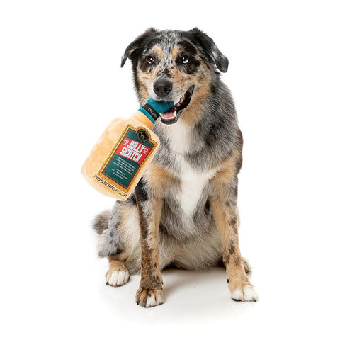 FuzzYard Xmas Jolly Scotch – hond speelt met pluche hondenspeeltje in de vorm van een whiskyfles met kerstmuts