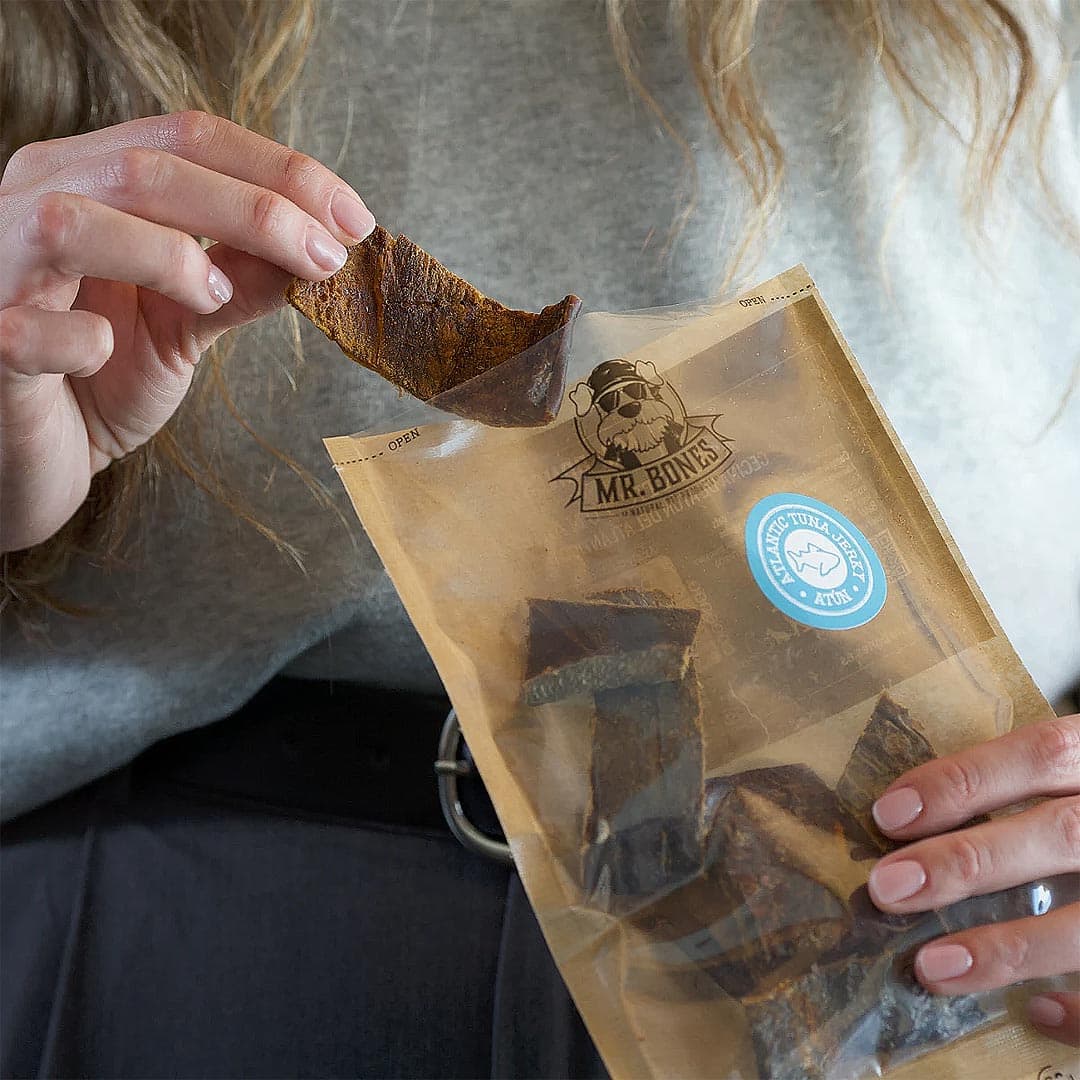 Mr. Bones Atlantische Tonijn Jerky – harde stukjes tonijn met stevige bite, vastgehouden in de hand