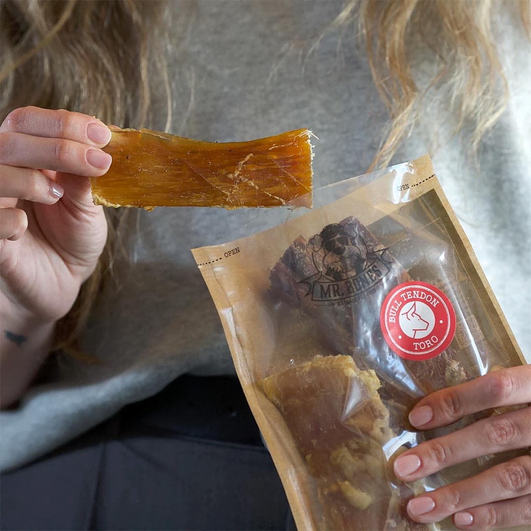 Mr. Bones Runderpezen – platte runderpezen met taaie structuur en stevige bite, vastgehouden in de hand