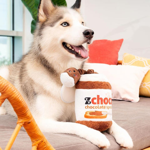 Hond ligt met ZippyPaws Bungee Burrow interactief hondenspeelgoed en intelligentiespel – chocoladepasta pot met elastisch bungeekoord & Marshmallow Miniz knuffels met piepers